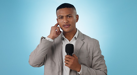 Image showing Portrait, man and reporter with mic on blue background for mock up in studio in Cape Town. Male journalist, model and listening for breaking news, update or announcement for broadcast in live stream