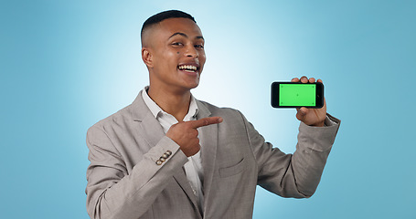 Image showing Business man, phone green screen and pointing to presentation, sign up information or trading software in studio. Happy portrait of a young trader on mobile app, tracking markers and blue background