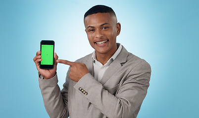 Image showing Professional man, phone green screen and pointing to presentation, sign up or website or trading software in studio. Portrait of business trader on mobile mockup, tracking markers and blue background