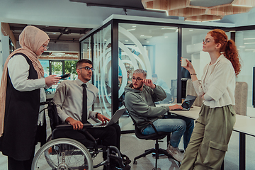 Image showing Young group of business people brainstorming together in a startup space, discussing business projects, investments, and solving challenges.