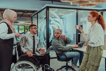 Image showing Young group of business people brainstorming together in a startup space, discussing business projects, investments, and solving challenges.