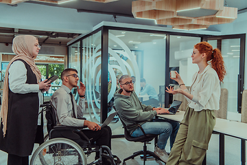 Image showing Young group of business people brainstorming together in a startup space, discussing business projects, investments, and solving challenges.