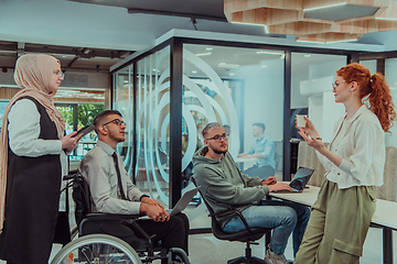 Image showing Young group of business people brainstorming together in a startup space, discussing business projects, investments, and solving challenges.