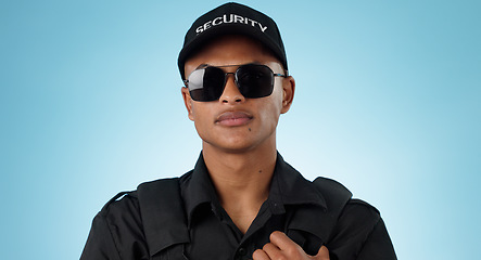 Image showing Security guard, portrait and man in studio with glasses for surveillance, justice and law enforcement on blue background. Serious bodyguard for crime prevention, safety patrol and monitoring danger