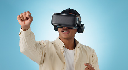 Image showing Man, punch and virtual reality glasses in studio for gaming, 3D user experience and metaverse by blue background. Person, gamer and ar vision with fight, competition and esports contest for boxing