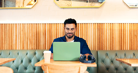 Image showing Man in coffee shop, typing on laptop and remote work, reading email and writing blog, article and research in restaurant. Computer, freelancer and editor in cafe, store and technology for internet