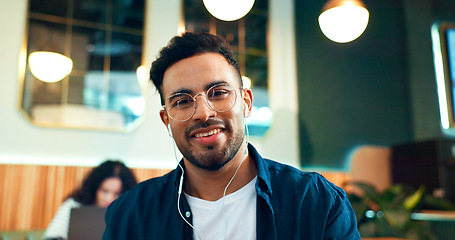 Image showing Man, portrait and smile with glasses in restaurant for relax, remote work or networking with earphones in the morning. Person, face and listening to music for peace, coffee break or happiness in cafe