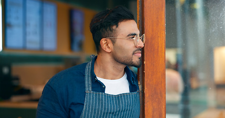 Image showing Small business, coffee shop and a man waiter thinking about hospitality service at the entrance to a restaurant. Face, idea and a young startup entrepreneur working as a barista in a local cafe