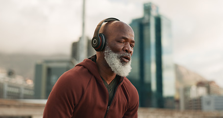 Image showing Man, headphones and tired from exercise, city and challenge in outdoor fitness, fatigue and dehydrated. Black mature person, exhausted and workout in retirement, listen and streaming radio or podcast