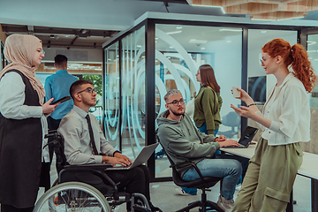 Image showing Young group of business people brainstorming together in a startup space, discussing business projects, investments, and solving challenges.