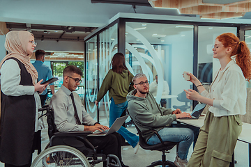 Image showing Young group of business people brainstorming together in a startup space, discussing business projects, investments, and solving challenges.