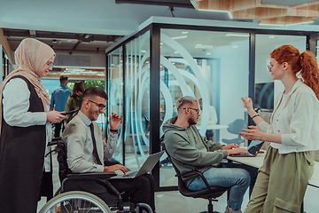 Image showing Young group of business people brainstorming together in a startup space, discussing business projects, investments, and solving challenges.