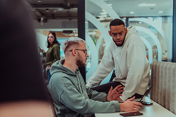 Image showing Young group of business people brainstorming together in a startup space, discussing business projects, investments, and solving challenges.