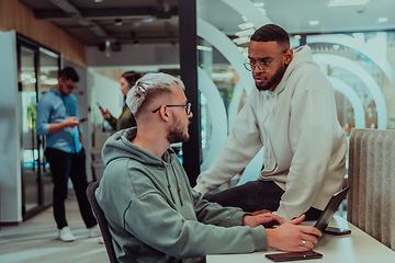 Image showing Young group of business people brainstorming together in a startup space, discussing business projects, investments, and solving challenges.