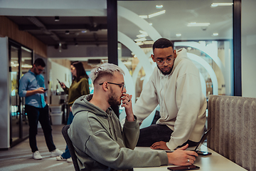 Image showing Young group of business people brainstorming together in a startup space, discussing business projects, investments, and solving challenges.