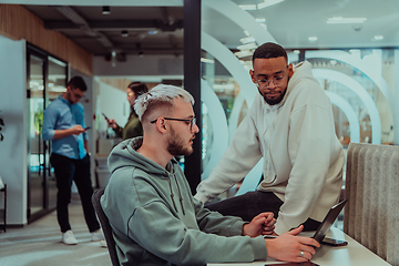 Image showing Young group of business people brainstorming together in a startup space, discussing business projects, investments, and solving challenges.