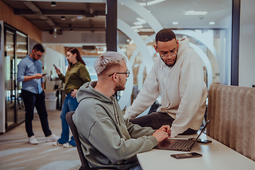 Image showing Young group of business people brainstorming together in a startup space, discussing business projects, investments, and solving challenges.