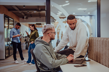 Image showing Young group of business people brainstorming together in a startup space, discussing business projects, investments, and solving challenges.