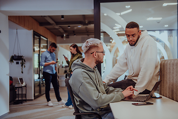 Image showing Young group of business people brainstorming together in a startup space, discussing business projects, investments, and solving challenges.