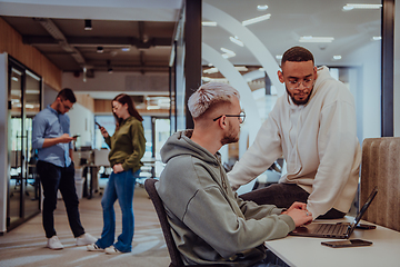 Image showing Young group of business people brainstorming together in a startup space, discussing business projects, investments, and solving challenges.