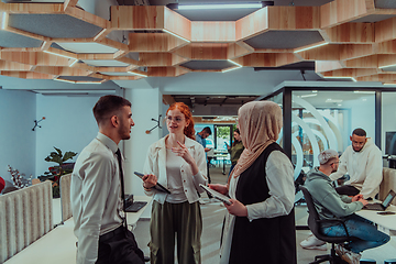 Image showing Young group of business people brainstorming together in a startup space, discussing business projects, investments, and solving challenges.