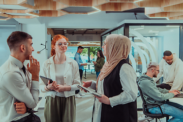 Image showing Young group of business people brainstorming together in a startup space, discussing business projects, investments, and solving challenges.