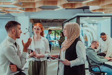 Image showing Young group of business people brainstorming together in a startup space, discussing business projects, investments, and solving challenges.