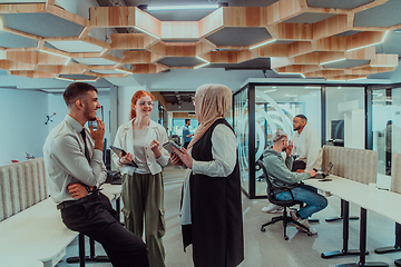 Image showing Young group of business people brainstorming together in a startup space, discussing business projects, investments, and solving challenges.