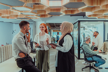 Image showing Young group of business people brainstorming together in a startup space, discussing business projects, investments, and solving challenges.