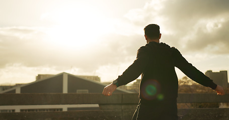 Image showing Man, workout and fitness by sunrise in city, back and warmup by cloudy sky, healthy and exercise. Male person, performance and body wellness in cardio, mental health and peace in dawn, outdoor or run