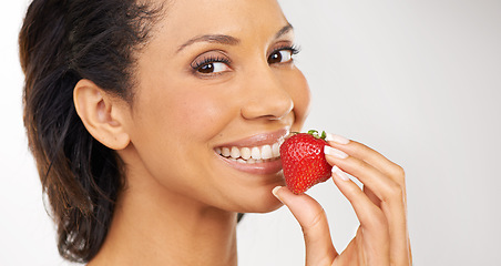 Image showing Smile, strawberry and portrait of woman in studio for wellness, nutrition and organic diet. Happy, vitamins and young female person from Mexico eating fruit for health vegan snack by gray background.