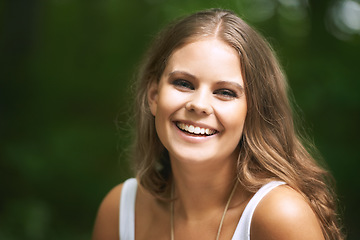 Image showing Portrait, smile and a woman in the forest on a green background for freedom, travel or to relax. Face, beauty and a happy young person in the countryside or woods for wellness or stress relief