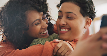 Image showing Phone, hug and an lgbt couple laughing together in their home while browsing a social media app. Gay, love and comedy with happy lesbian women looking at memes on a mobile for fun or romantic bonding