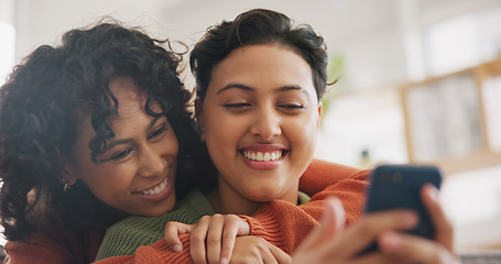 Image showing Phone, hug and a gay couple laughing together in their home while browsing a social media app. LGBT, love and comedy with happy lesbian women looking at a meme on a mobile for fun, romance or bonding