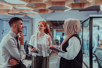 Image showing Young group of business people brainstorming together in a startup space, discussing business projects, investments, and solving challenges.