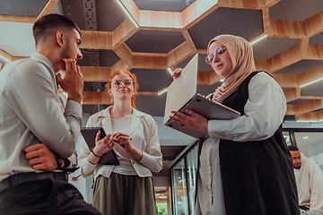 Image showing Young group of business people brainstorming together in a startup space, discussing business projects, investments, and solving challenges.