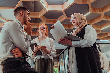 Image showing Young group of business people brainstorming together in a startup space, discussing business projects, investments, and solving challenges.