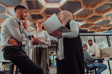 Image showing Young group of business people brainstorming together in a startup space, discussing business projects, investments, and solving challenges.