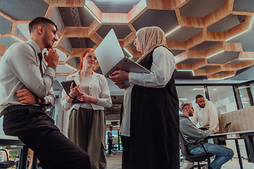 Image showing Young group of business people brainstorming together in a startup space, discussing business projects, investments, and solving challenges.