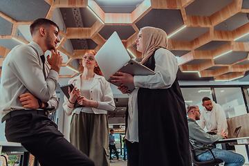 Image showing Young group of business people brainstorming together in a startup space, discussing business projects, investments, and solving challenges.