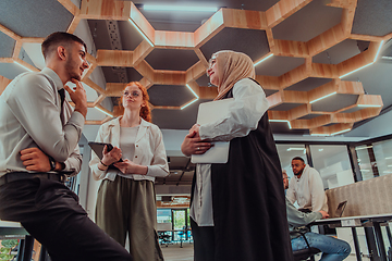 Image showing Young group of business people brainstorming together in a startup space, discussing business projects, investments, and solving challenges.