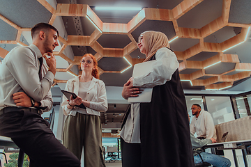 Image showing Young group of business people brainstorming together in a startup space, discussing business projects, investments, and solving challenges.