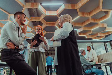 Image showing Young group of business people brainstorming together in a startup space, discussing business projects, investments, and solving challenges.