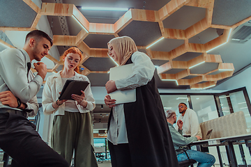 Image showing Young group of business people brainstorming together in a startup space, discussing business projects, investments, and solving challenges.