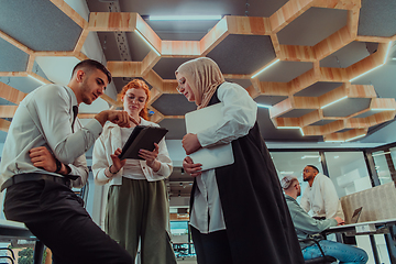 Image showing Young group of business people brainstorming together in a startup space, discussing business projects, investments, and solving challenges.