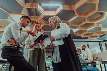 Image showing Young group of business people brainstorming together in a startup space, discussing business projects, investments, and solving challenges.