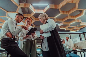 Image showing Young group of business people brainstorming together in a startup space, discussing business projects, investments, and solving challenges.