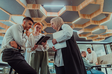 Image showing Young group of business people brainstorming together in a startup space, discussing business projects, investments, and solving challenges.