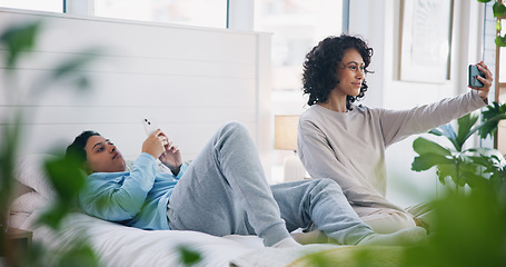 Image showing Smile, phone and lesbian couple on bed in selfie, love and relax together in eco friendly apartment. Cellphone, social media and digital photography, happy lgbt women in bedroom in home with plants.