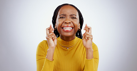 Image showing Fingers crossed, praying and black woman in studio with sign of good luck for bonus, prize or lottery in white background. Hope, wish and nervous person with hands, emoji and waiting for results